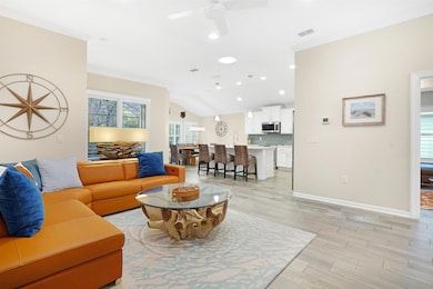 Living room with wood tiled floors, recessed lighting, ornamental molding, a ceiling fan, and lofted ceiling