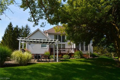 Back of house featuring a pergola, a lawn, and wooden deck
