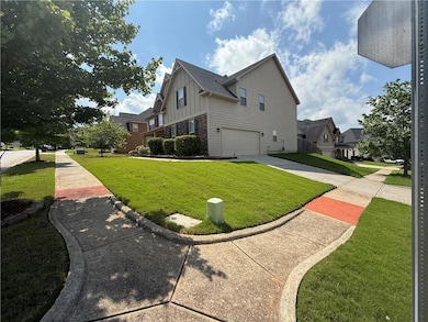 View of side of home with board and batten siding, an attached garage, driveway, and a yard