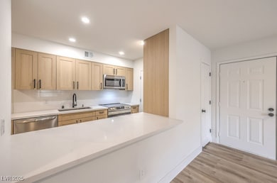 Kitchen featuring a peninsula, appliances with sta