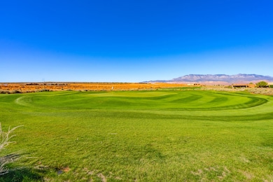 View of community with view of golf course, a yard, and a mountain view