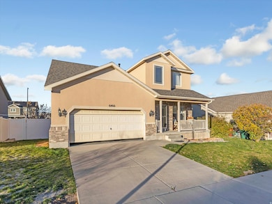 View of front facade with a porch, concrete driveway, stucco siding, an attached garage, and stone siding