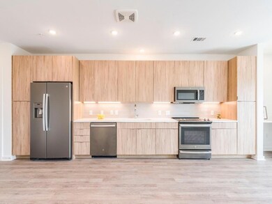 Kitchen with stainless steel appliances, light br