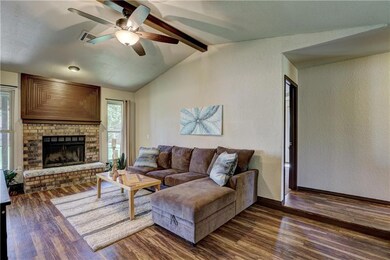 Living room has wood burning fire place, warm wood