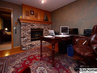 Gas log fireplace shared with family room, built in book shelves and cabinetry, hardwood floors.