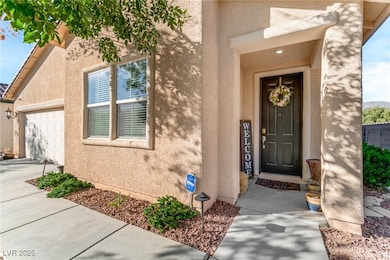 Property entrance featuring stucco siding, driveway, and an attached garage