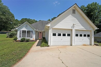Ranch-style house with concrete driveway, a front yard, and a garage