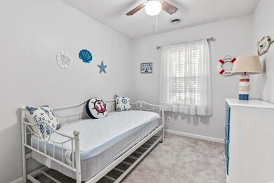 Carpeted bedroom featuring ceiling fan