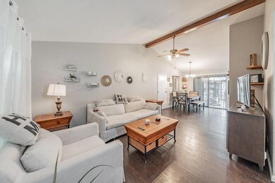 Living room featuring high vaulted ceiling, beamed