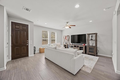Living room featuring visible vents, wood finishe