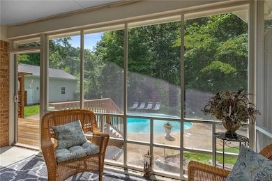 Sunroom featuring plenty of natural light and view of scattered trees