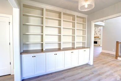Interior space with light wood-style floors, a fireplace, and a chandelier