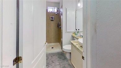 Full bath with vanity, a stall shower, and a textured wall