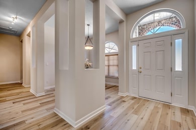 Foyer entrance with a textured ceiling and light h