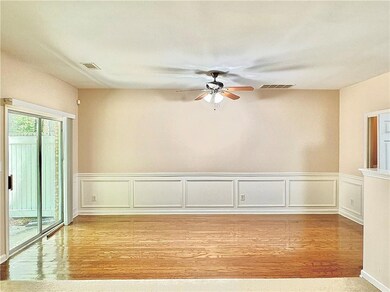 Unfurnished room with ceiling fan, light wood finished floors, a wainscoted wall, and a decorative wall