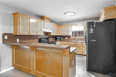 Kitchen with sink, black appliances, tasteful backsplash, and kitchen peninsula