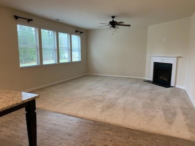 Unfurnished living room with a fireplace with flush hearth, wood finished floors, and a ceiling fan