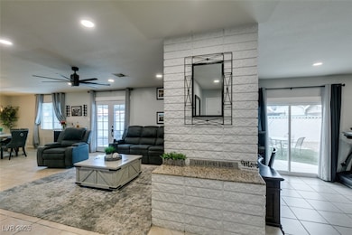 Living room with a ceiling fan, tile patterned flooring, recessed lighting, and french doors