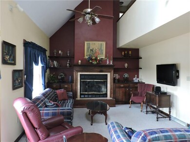 This 2 story living room has a gas fireplace, skyl