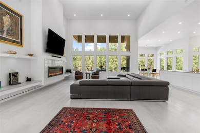 Living room with high-end commercial grade, waterproof, low maintenance vinyl floors, a tiled fireplace, a towering ceiling, and recessed lighting, & 85