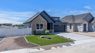 View of front of home featuring board and batten siding, a gate, concrete driveway, stone siding, and a garage