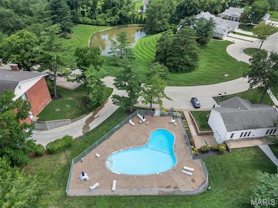 Aerial overview of property's location featuring a nearby body of water and a pool