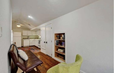 Living area featuring a ceiling fan, dark wood-ty