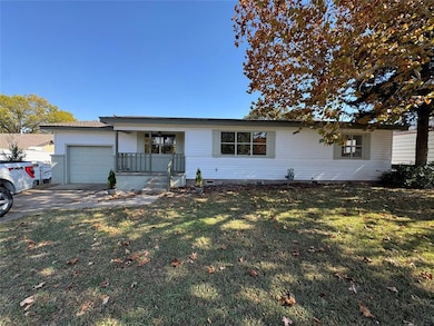 Ranch-style home featuring crawl space, a front yard, covered porch, a garage, and driveway