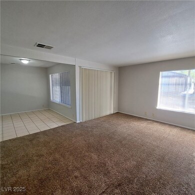 Empty room featuring light carpet, a textured ceil
