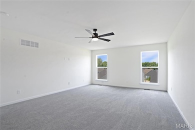 Spare room with carpet flooring, healthy amount of natural light, and a ceiling fan