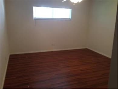 Spare room with dark wood-style flooring and base