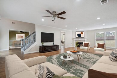 Living room with stairs, visible vents, wood finis
