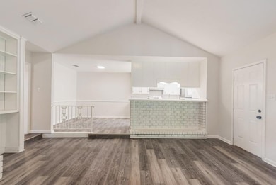 Unfurnished living room featuring dark hardwood / 