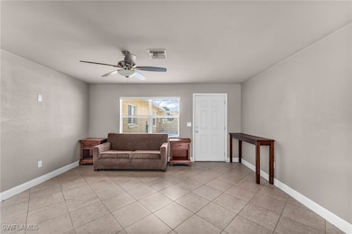 Sitting room with ceiling fan and light tile patte