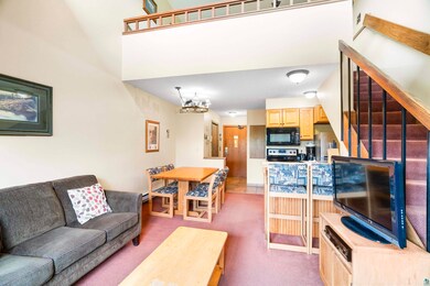 Carpeted living room featuring an inviting chandel