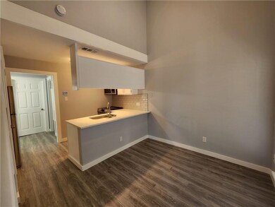 Kitchen featuring a sink, a peninsula, baseboards