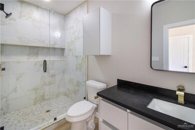 Bathroom with a marble finish shower and vanity