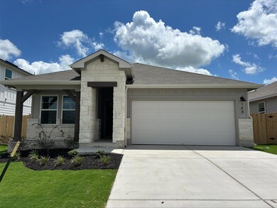 View of front of home featuring stone siding, a g