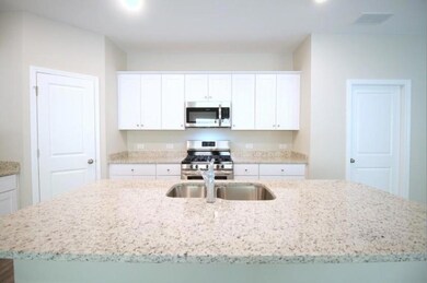 Kitchen with a sink, visible vents, white cabinets