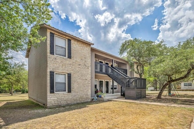Back of house with a patio, stone siding, a lawn, and stairs