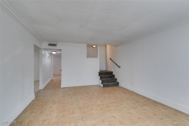 Basement with stairway, crown molding, and baseboa
