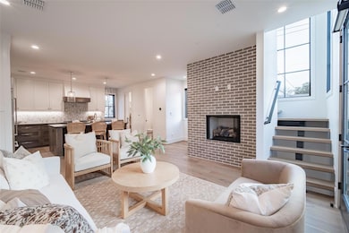 Living room with brick wall, a fireplace, and ligh