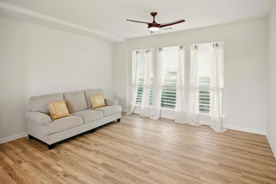 Living room with ceiling fan, light wood finished