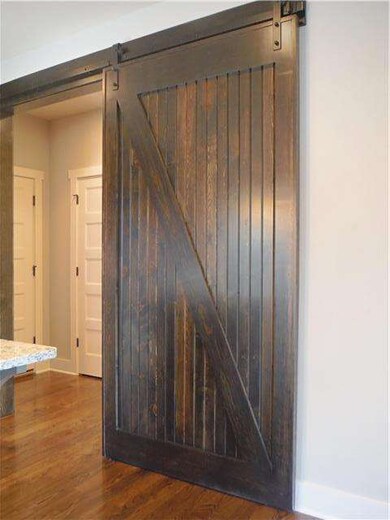 Barn door entrance to kitchen from drop zone.