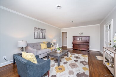Spacious living area with hardwood flooring, crown