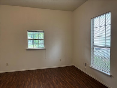 Spare room with dark wood finished floors and bas