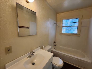 Full bathroom featuring bathing tub / shower combination, toilet, vanity, and a textured ceiling