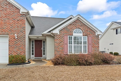 View of front of property with a garage, brick sid