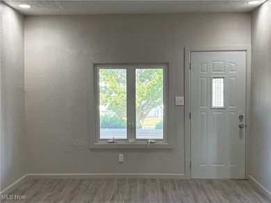 Entryway featuring a textured ceiling, light wood-style floors, and a textured wall
