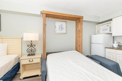 Bedroom featuring a textured ceiling, white refrig